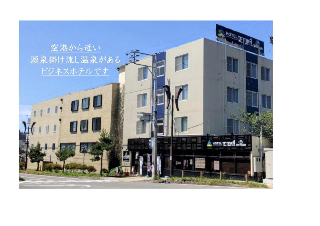 a building with a street sign in front of it at Hotel Tetora Yunokawaonsen in Hakodate