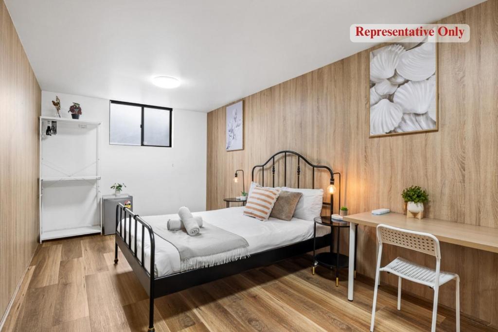 a bedroom with a bed and a desk in it at Cozy Bankstown Stayz in Bankstown