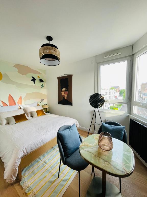 une chambre avec un lit, une table et des chaises dans l'établissement Lille / Marcq Au cœur du Croisé Laroche, à Marcq-en-Barœul