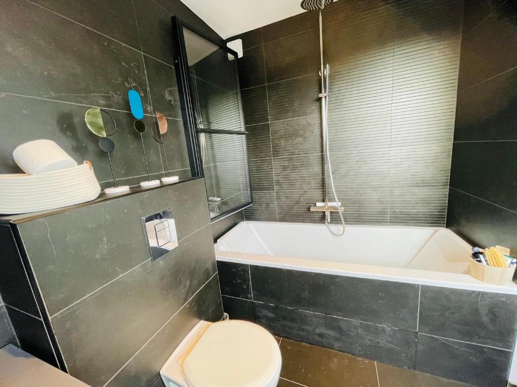 een badkamer met een bad, een toilet en een wastafel bij Lille / Marcq Au cœur du Croisé Laroche in Marcq-en-Baroeul