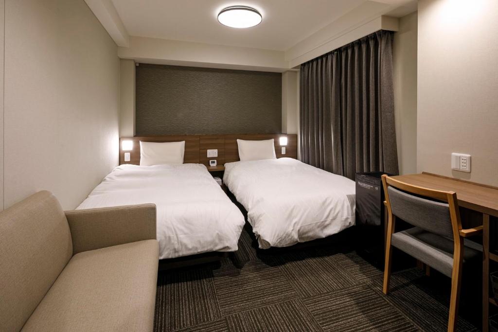 Postel nebo postele na pokoji v ubytování Dormy Inn Express Toyohashi
