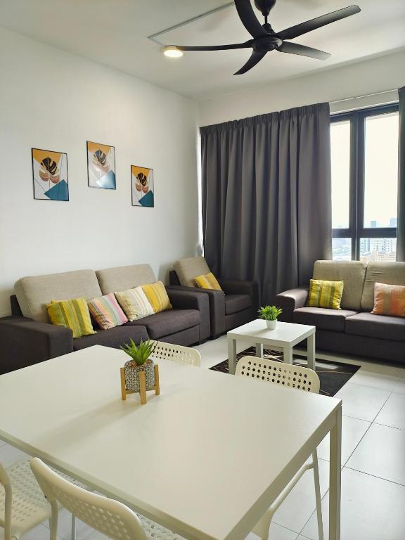 a living room with a white table and a couch at Luxury Comfort Suite 3BR in Jelutong