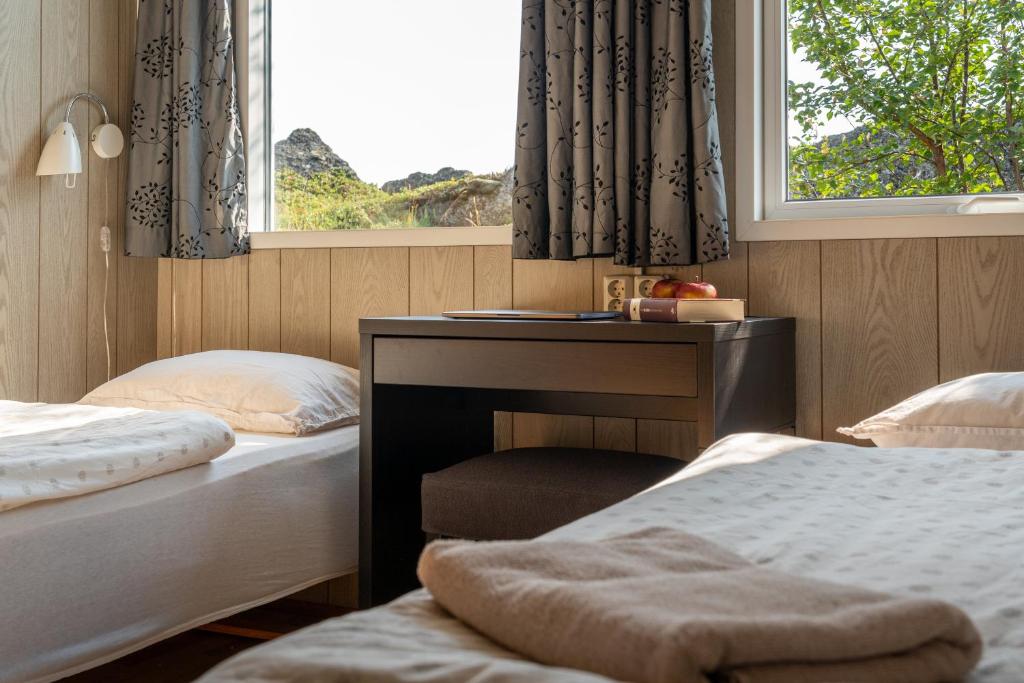 um quarto com 2 camas, uma secretária e uma janela em Vogar Travel Service em Myvatn