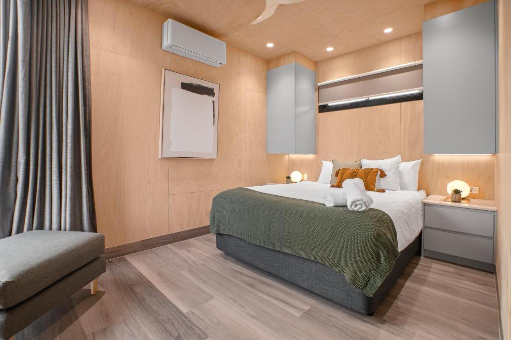 1 dormitorio con 1 cama grande y 1 silla en Tasman Holiday Parks - St Helens en St Helens