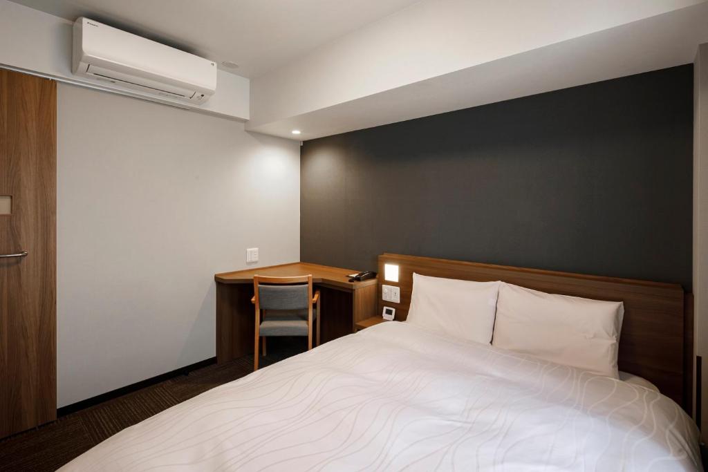 Postel nebo postele na pokoji v ubytování Dormy Inn Express Toyohashi