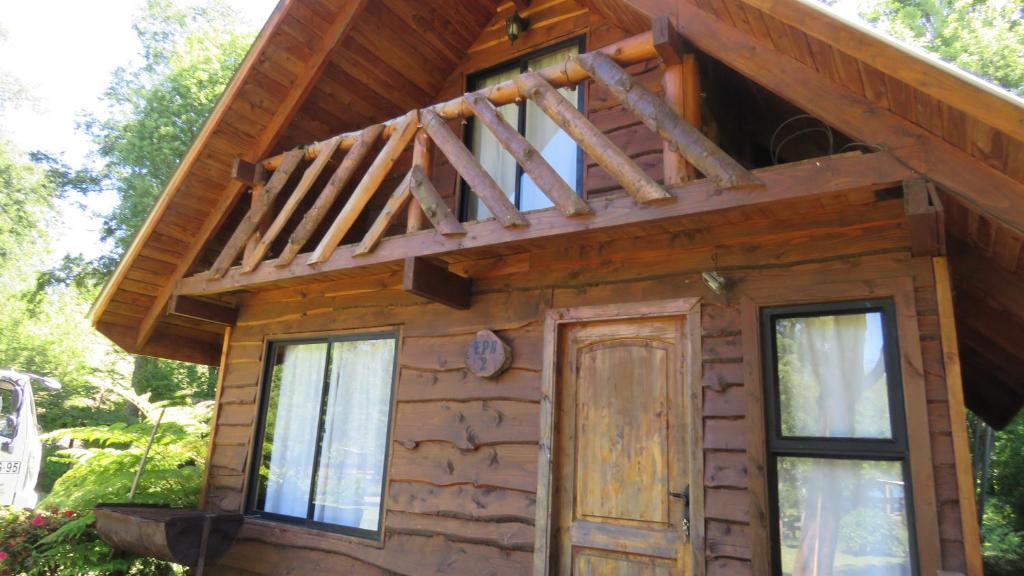 Cabaña de madera con porche y puerta en Cabañas Paihuén en Panguipulli