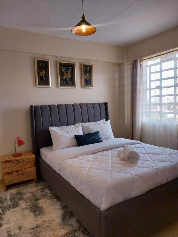 Un dormitorio con una cama grande y una ventana en Rawin Homes en Nyeri