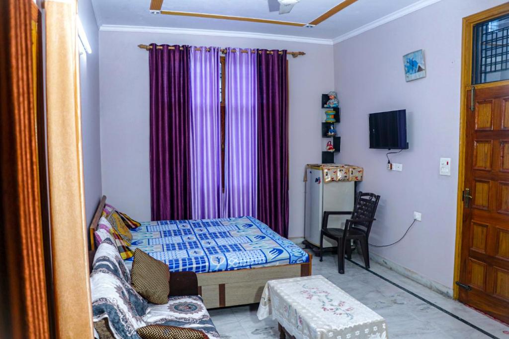 ラムナガルにあるChoudhary Mansionのベッド、ソファ、テレビが備わる客室です。