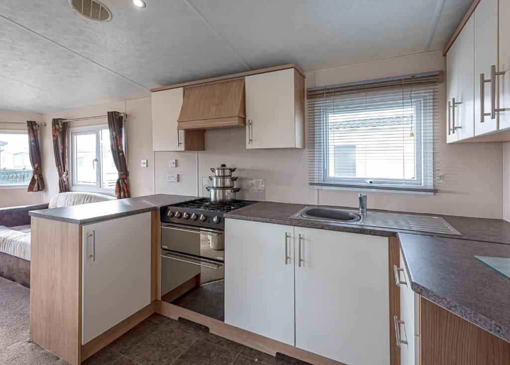 a kitchen with white cabinets and a counter top at Woodlands Hall in Ruthin