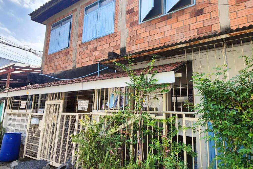 a brick house with a fence in front of it at 207:Homely room in apartment Near BTS Kasetsart U. in Bangkok