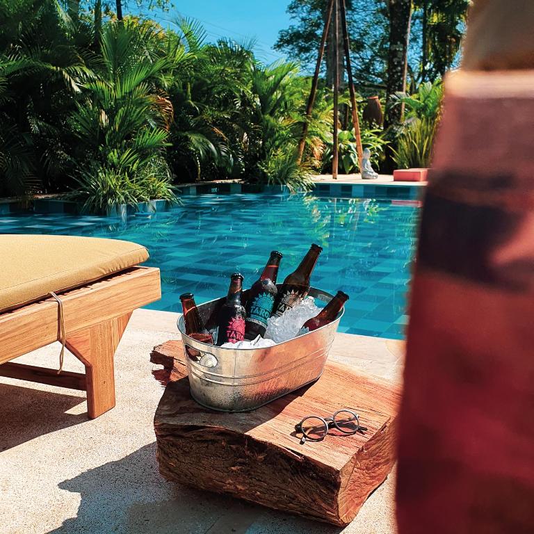 um balde de garrafas de cerveja numa mesa ao lado de uma piscina em Umbral Hotel Boutique em Villavicencio