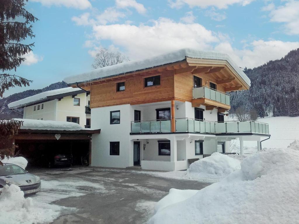 ein großes Gebäude mit Balkon im Schnee in der Unterkunft Ferienwohnung Emmerenzia in Söll