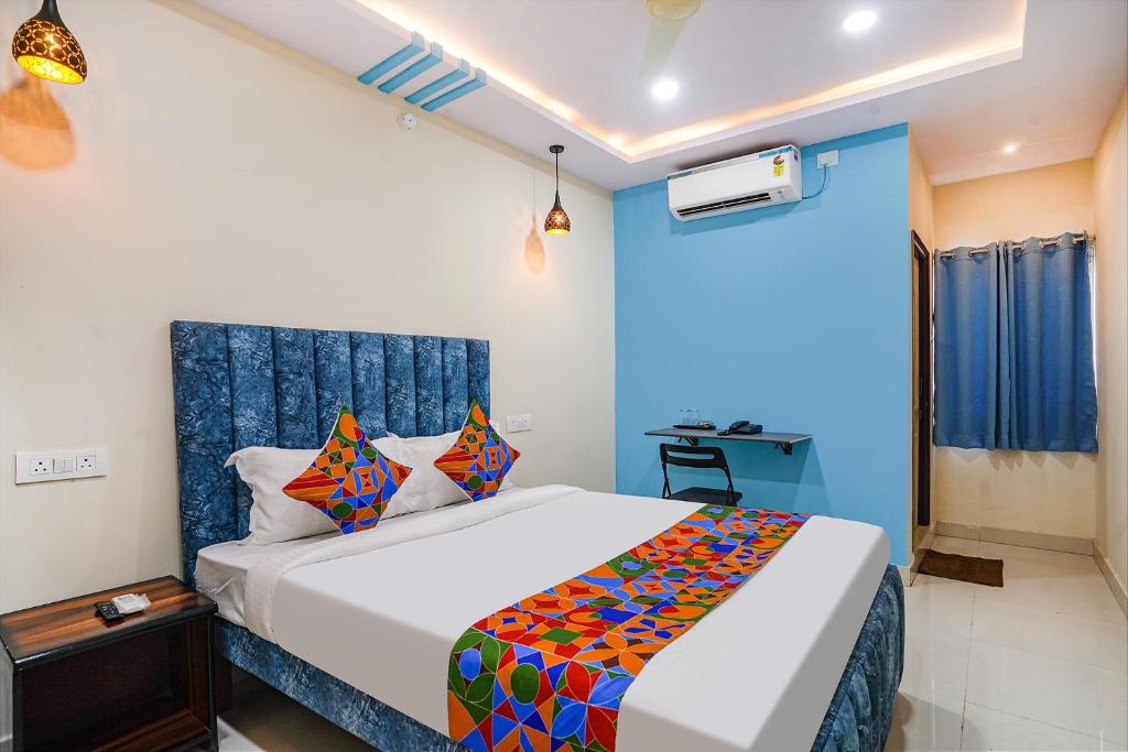 a bedroom with a bed and a blue wall at FabHotel Grand Broholic in Hyderabad