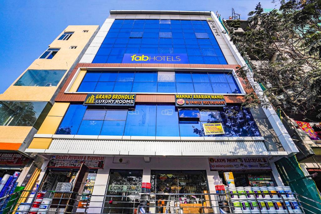 a tall building with a koi hotels sign on it at FabHotel Grand Broholic - Nr Hitech City in Hyderabad