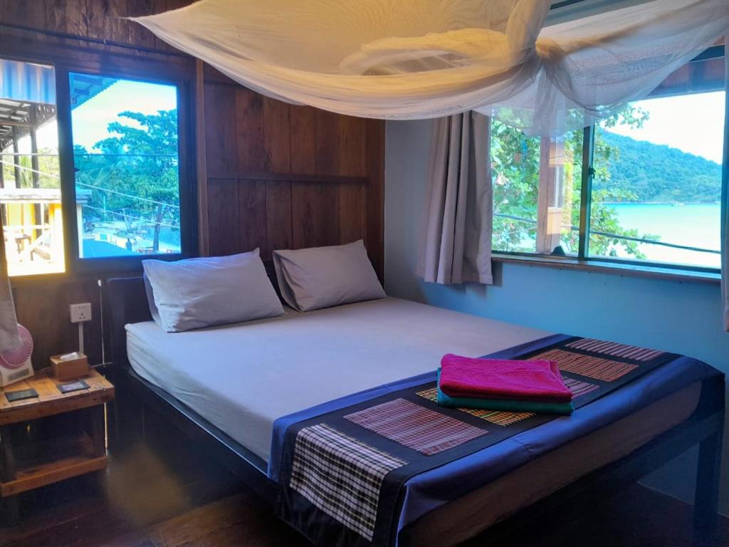 Cama en habitación con ventana en Bong's Guesthouse M'Pai Bay en Koh Rong Sanloem