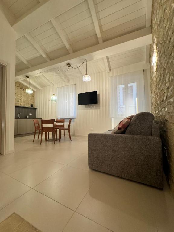 - un salon avec un canapé et une salle à manger dans l'établissement Appartamenti L'Ambulante, à Montefalco