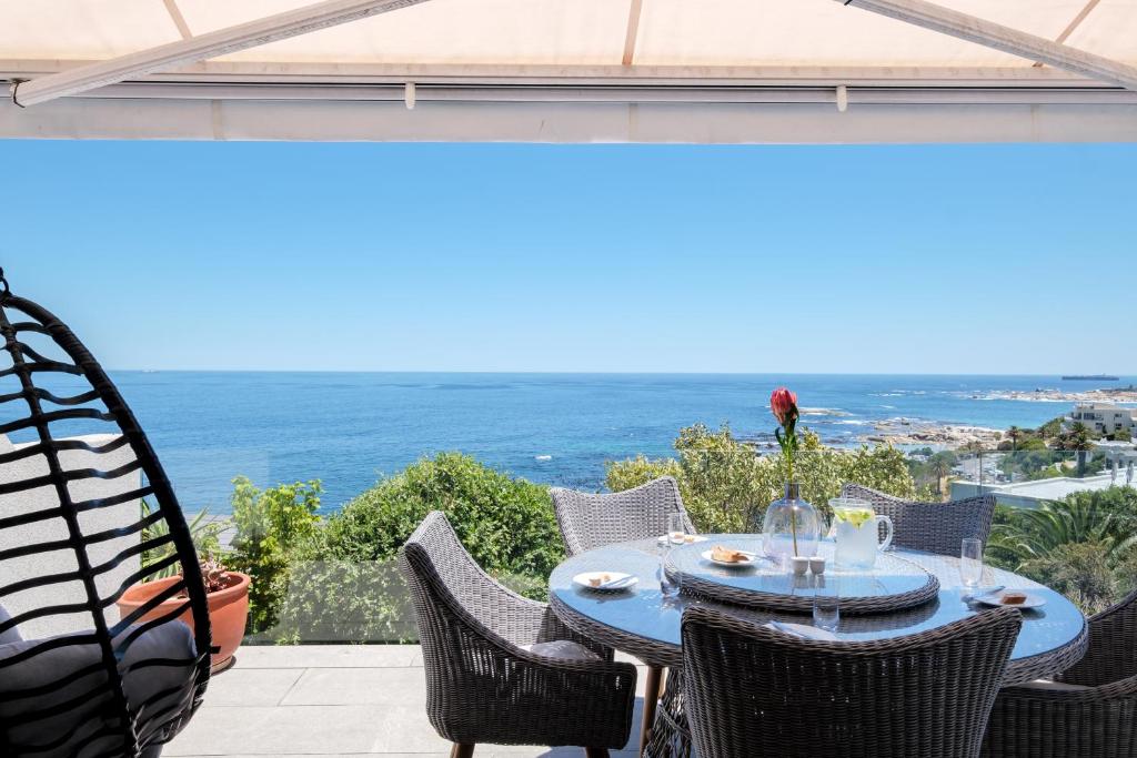 a table on a patio with a view of the ocean at Beach Steps in Cape Town