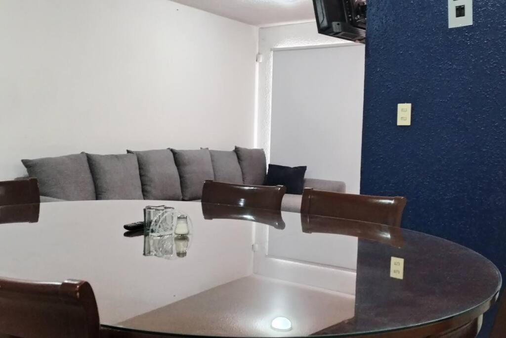 una mesa y sillas en una habitación con sofá en Casa Cuarzo Mineral de la Reforma, en Pachuca de Soto