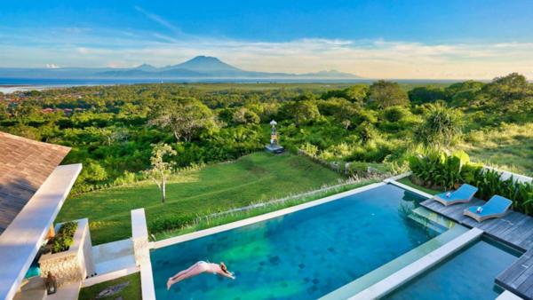 a person jumping into a swimming pool in a house at 353 Degrees North in Nusa Lembongan
