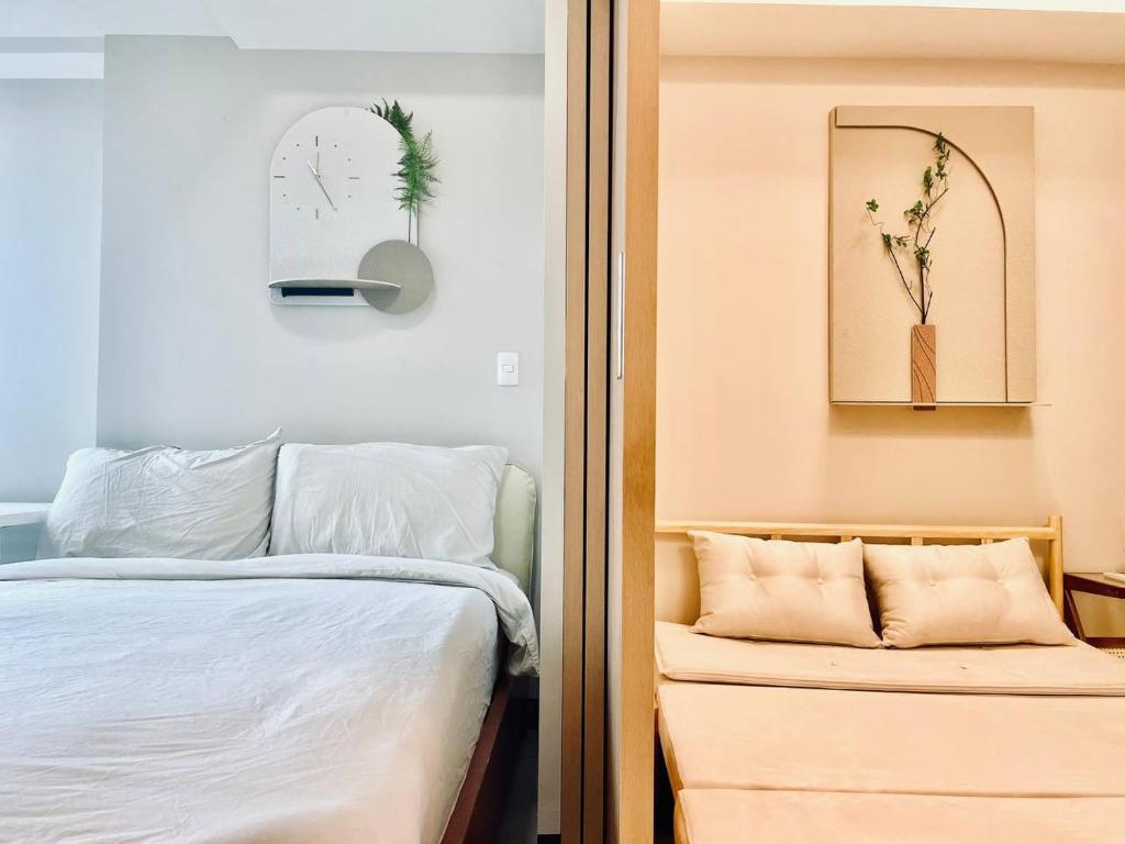 a bedroom with a bed and a clock on the wall at Thompson Suites - 2 beds, Uptown Parksuites Tower 1 25F in Manila