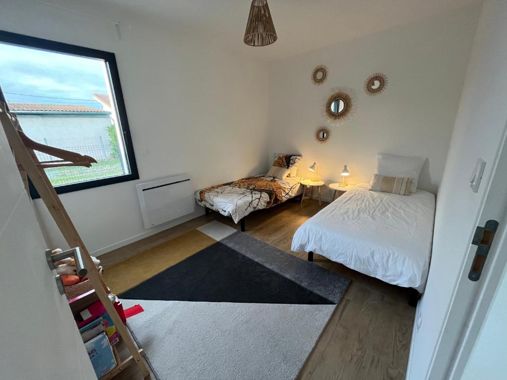 um pequeno quarto com 2 camas e uma janela em Agréable maison individuelle proche Bordeaux em Ambarès-et-Lagrave