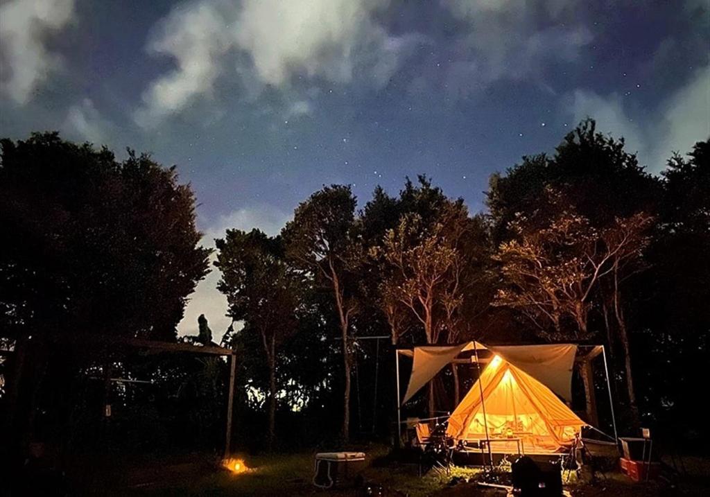 ein Zelt, das nachts auf einem Feld sitzt in der Unterkunft Katsuyama Basecamp - Camp - Vacation STAY 42349v in Yamanuha