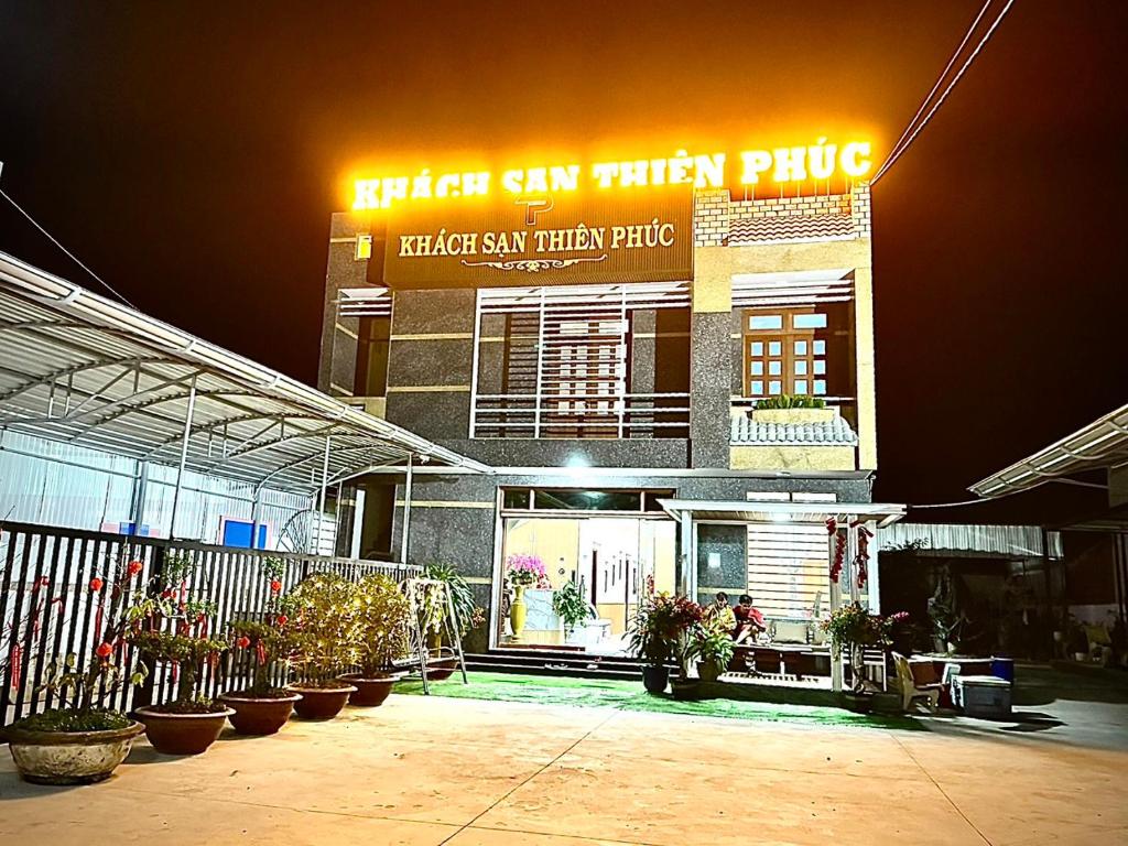 Thien Phuc Hotel في Ba Tri: مبنى أمامه نباتات الفخار