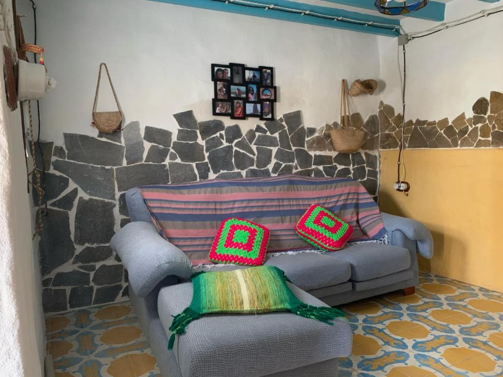 een woonkamer met een bank met twee kussens erop bij Antigua Aljibe in Espera