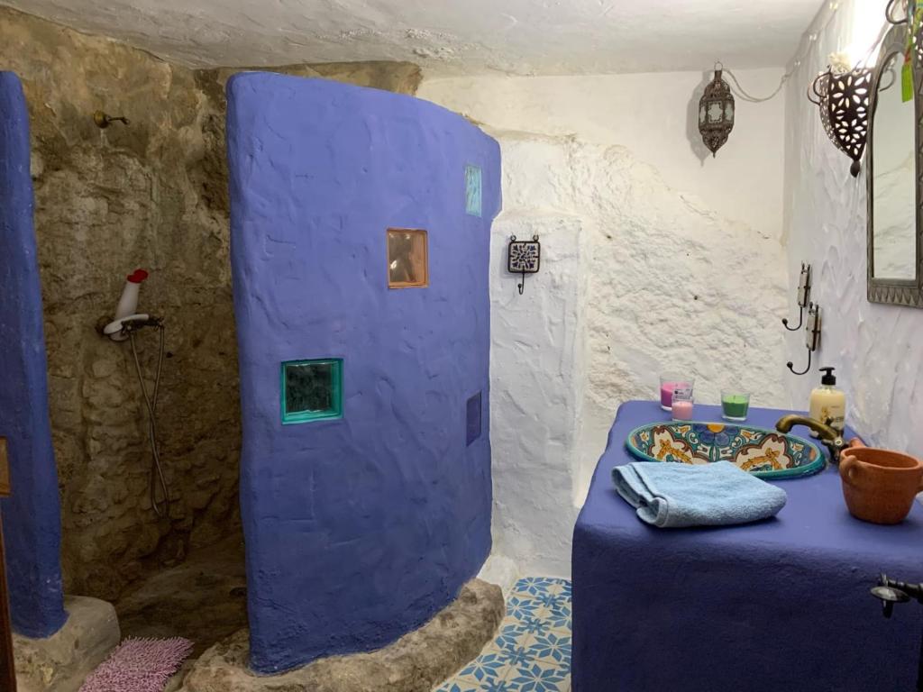 een kamer met een blauwe tafel en een muur bij Antigua Aljibe in Espera