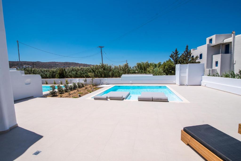 uma piscina com duas espreguiçadeiras ao lado de uma villa em Depis Edem private villas naxos em Plaka