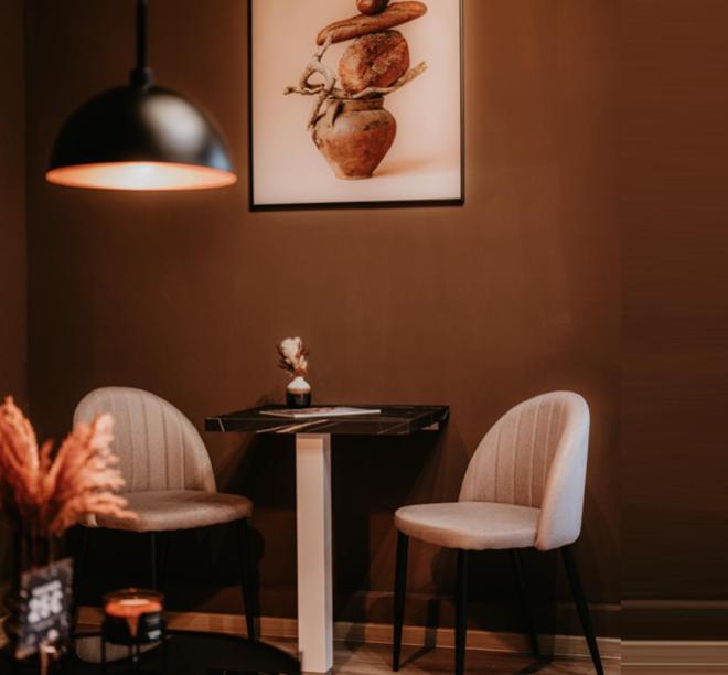 un tavolo e due sedie in una stanza con una foto di LLR Design Apartment - Sepia Toffee im Zentrum von Koblenz a Coblenza
