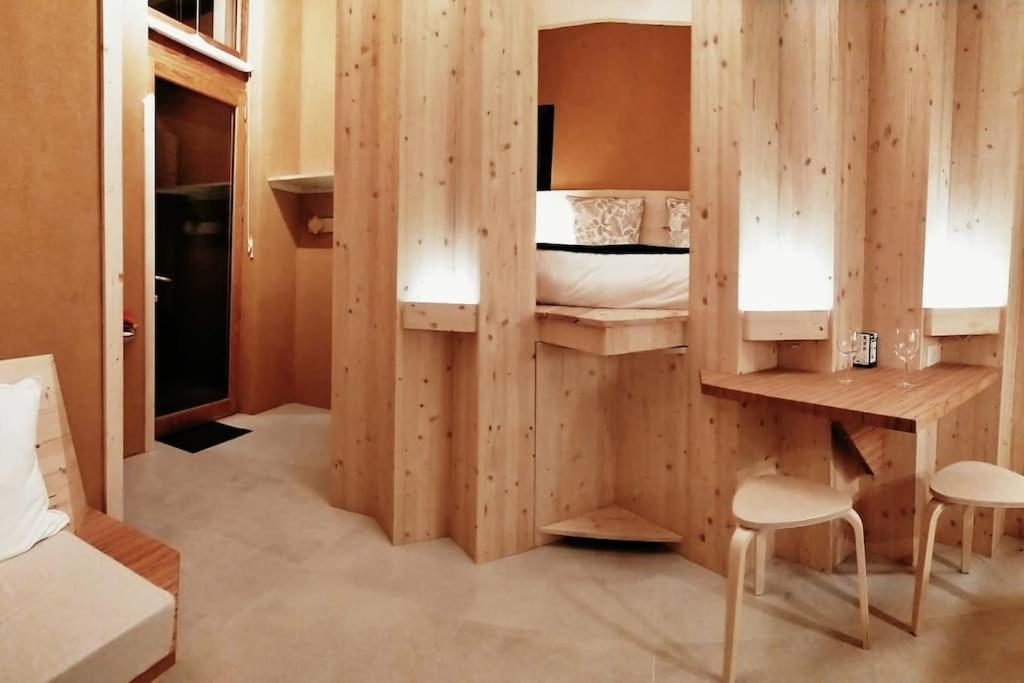 - une chambre dotée d'un mur en bois et d'un lit dans l'établissement Studio ambiance verdoyante et vue sur la vallée, à Auzeville-Tolosane