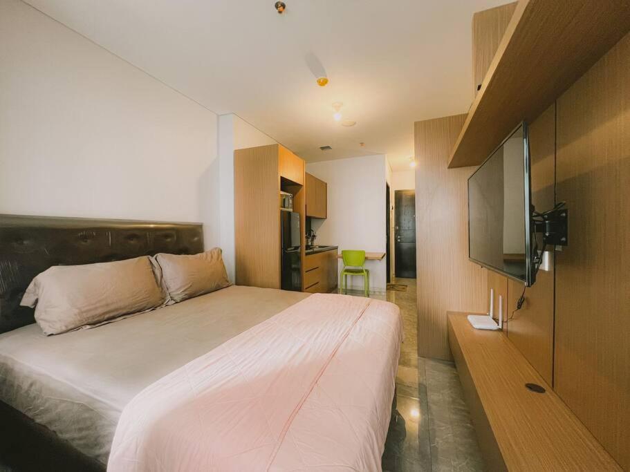 1 dormitorio con 1 cama y TV de pantalla plana en Vintage Oasis Retro Studio at Nifarro Apartment, en Yakarta