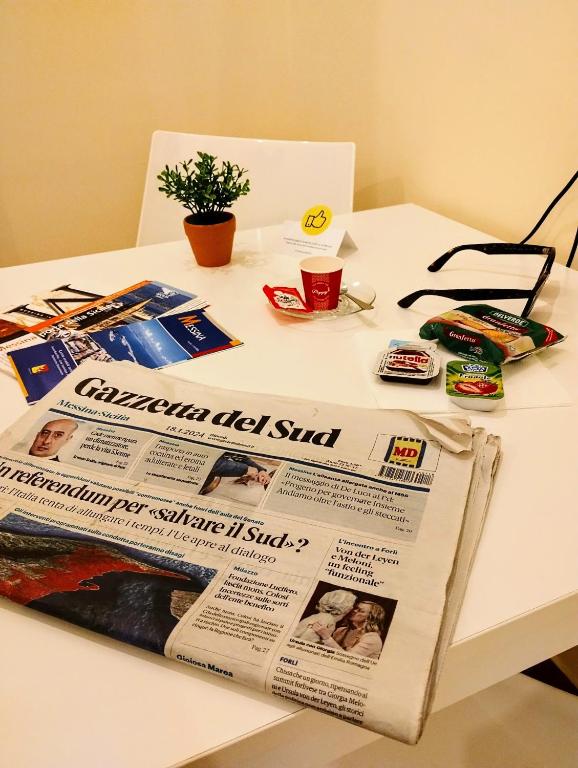 um jornal sentado em cima de uma mesa branca em Suleima B&B Messina Centro em Messina