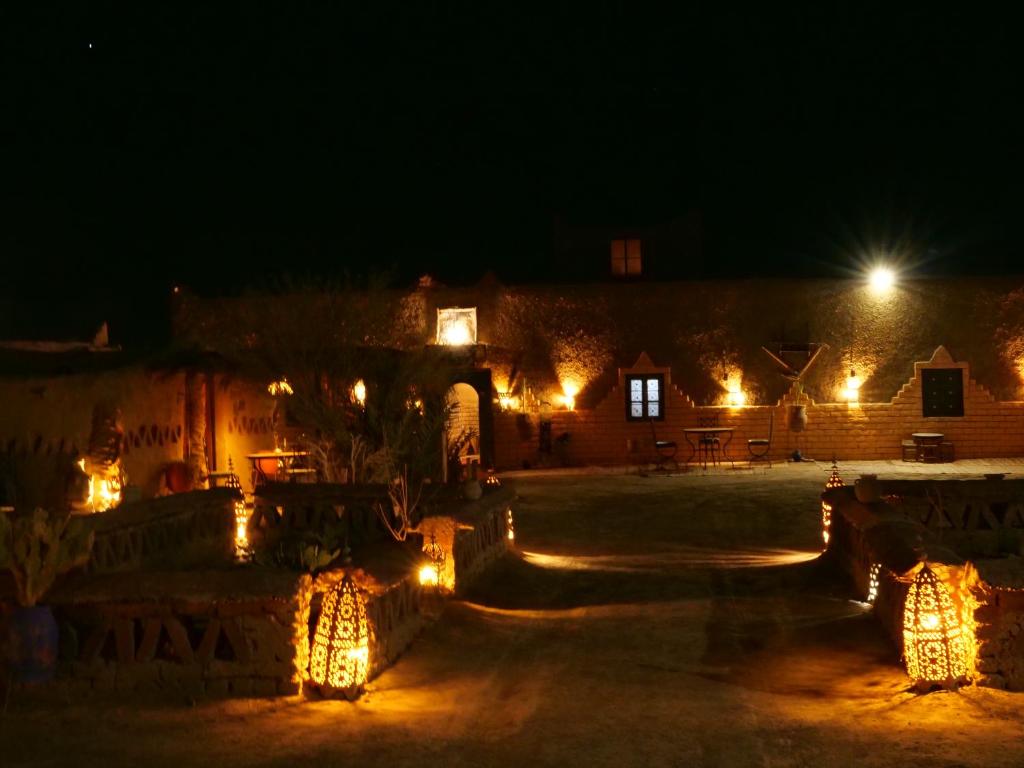 Una vista nocturna de un edificio con luces. en kasbah Planet Sahara, en Merzouga