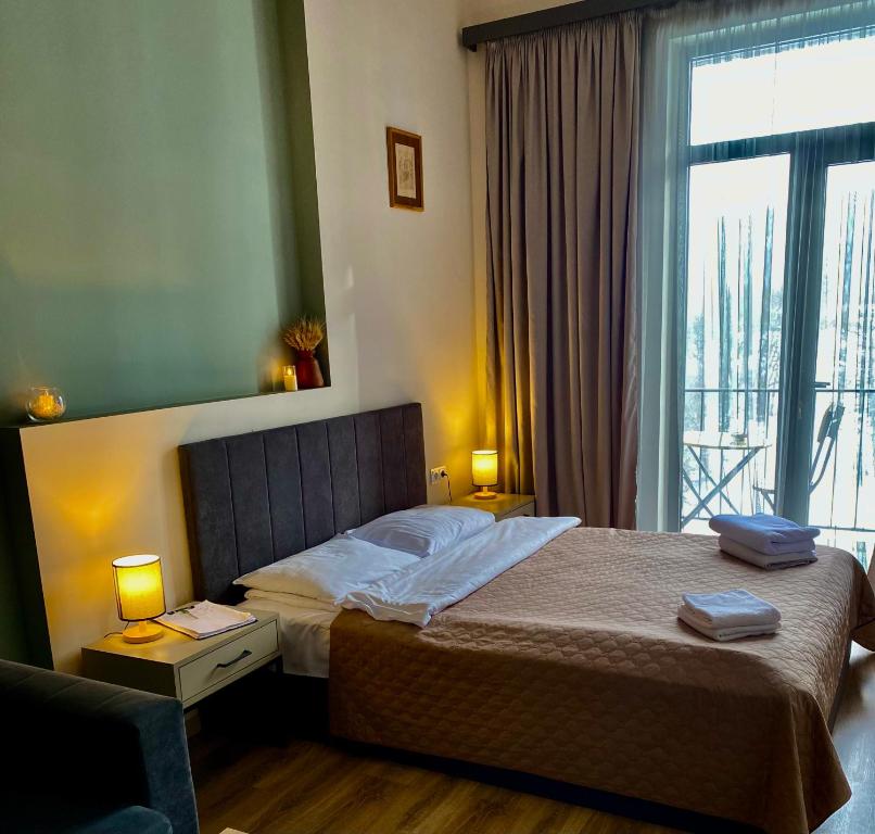 een slaapkamer met een bed en een groot raam bij Apartment #102 in aparthotel in Tsachkadzor