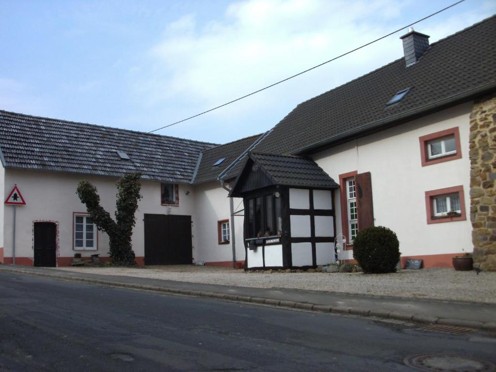 una casa blanca con techo negro en una calle en Haus Klara, en Mannebach