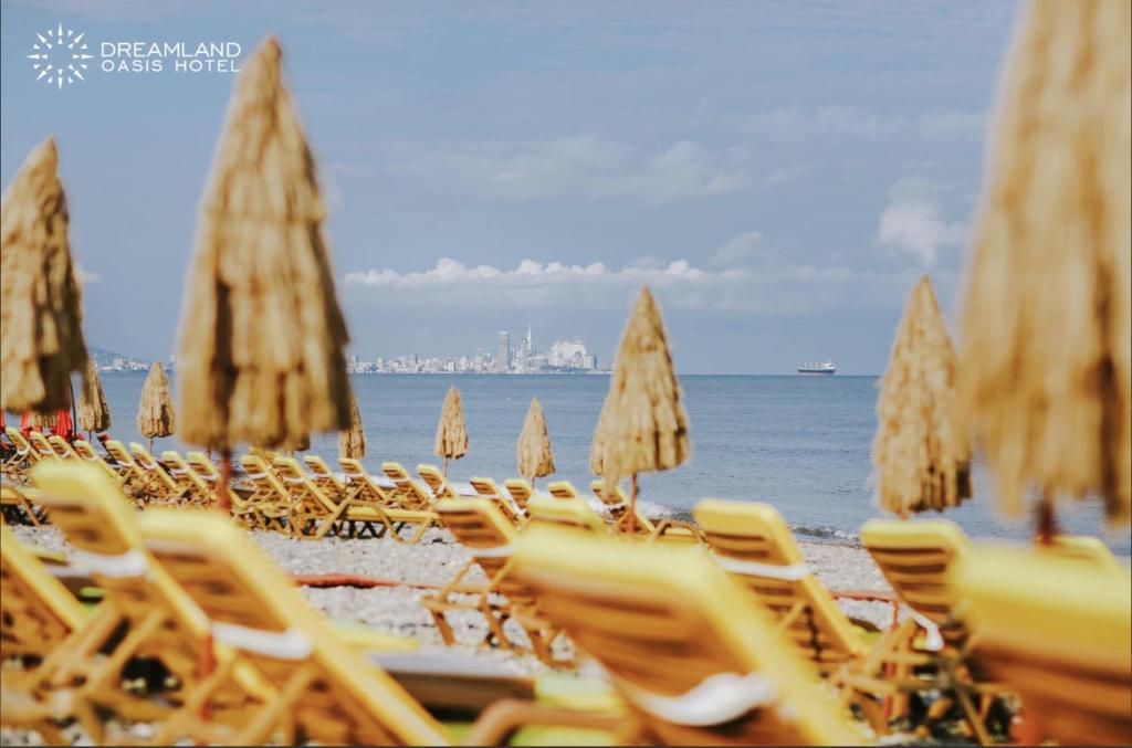 a group of chairs and umbrellas on a beach at Dreamland Oasis 1st floor Apartment With a Garden by the Sea in Chakvi