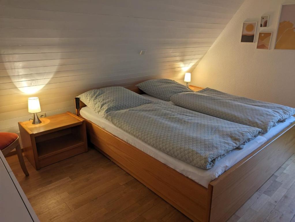 two beds in a room with two lamps on tables at Ferienwohnung im Hambach in Bad Berleburg