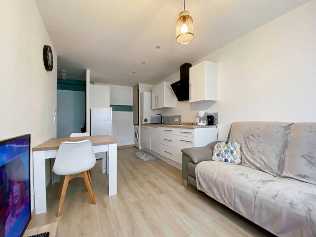 uma sala de estar com um sofá, uma mesa e uma cozinha em Le Saint Pierre - T2 refait em Saint-Pierre-de-Chandieu