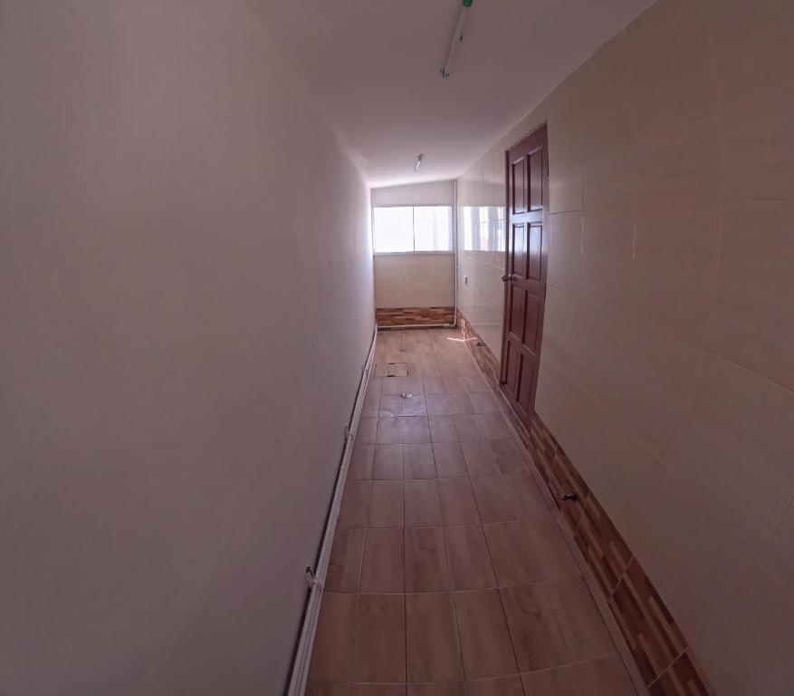an empty hallway with a wooden floor and a window at Pattaya pool villa in Ban Huai Yai