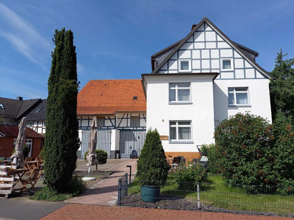 une maison blanche avec un toit rouge dans l'établissement Pension Bitter, à Reinhardshausen