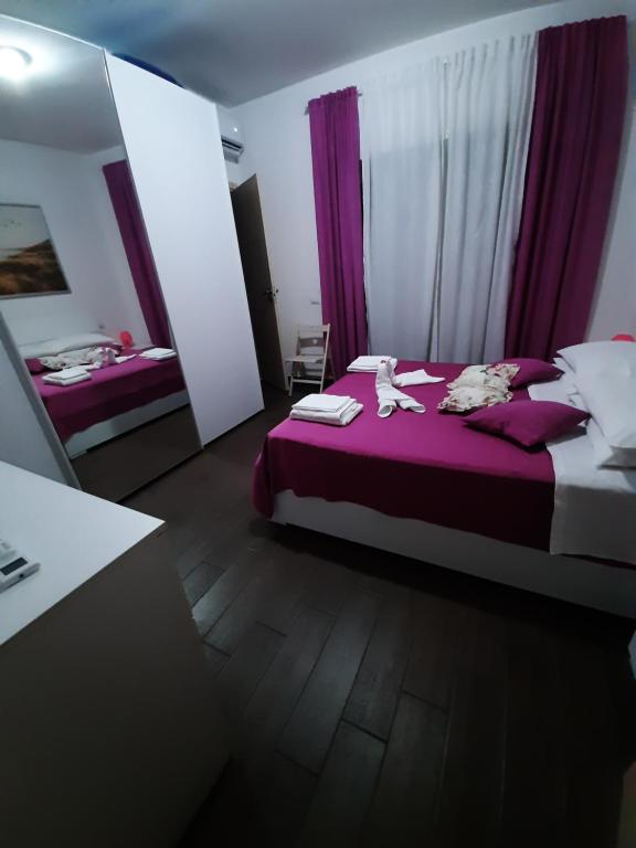 - une chambre avec un lit violet et un miroir dans l'établissement Da Lucia, à Rome