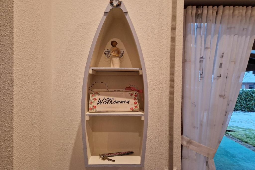 une étagère dans un mur avec un gâteau et une planche de surf dans l'établissement Ferienhaus LandMeer, à Gödenstorf