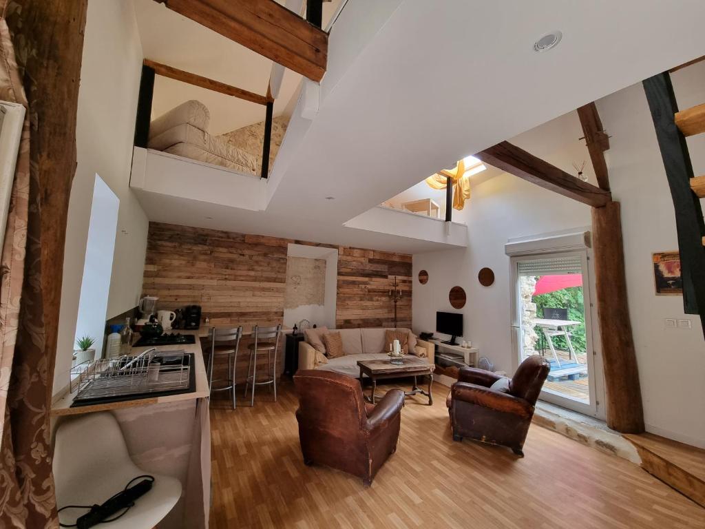 uma cozinha e sala de estar com vigas expostas em Maison Oscar et Petrus em Beaumont-du-Gâtinais