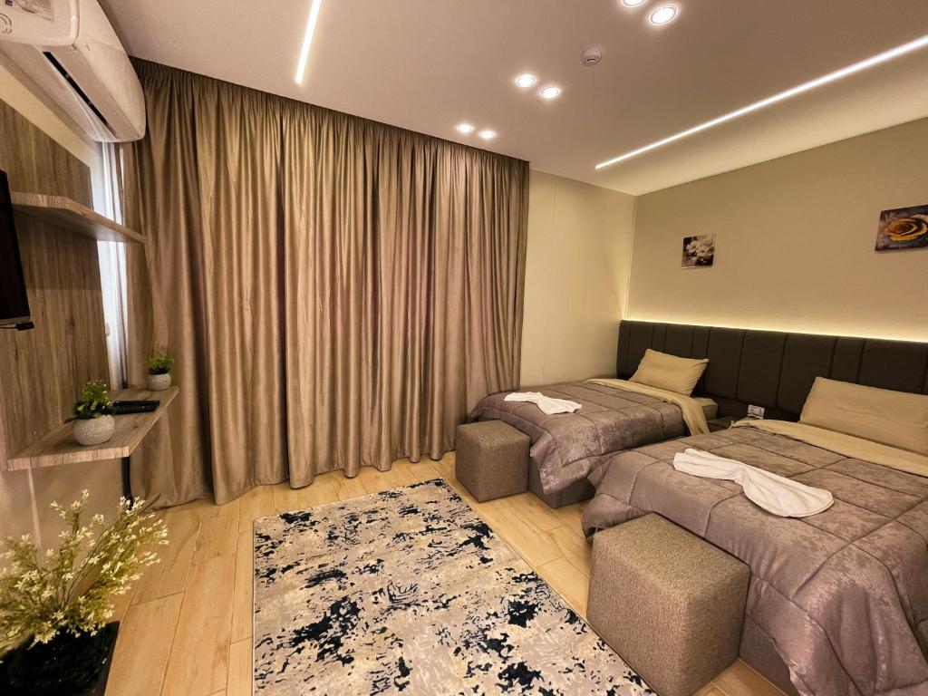 une chambre d'hôtel avec deux lits et un canapé dans l'établissement Holy Sheet Plus, au Caire