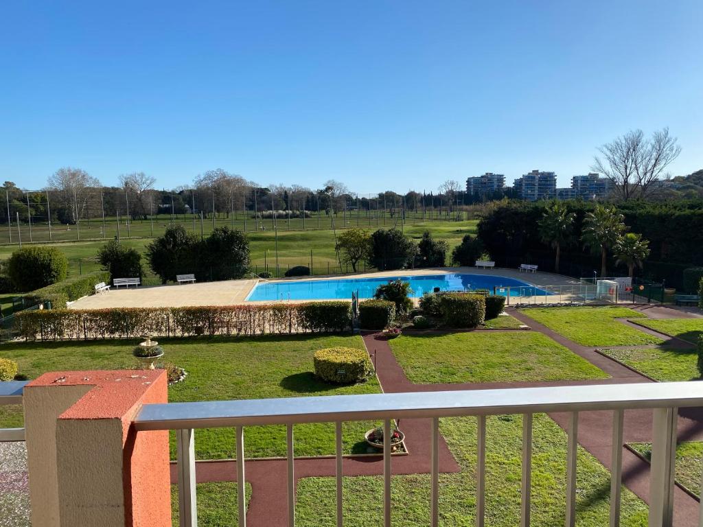 Una vista de una piscina desde un balcón. en Joli appartement calme avec vue piscine, en Mandelieu-la-Napoule
