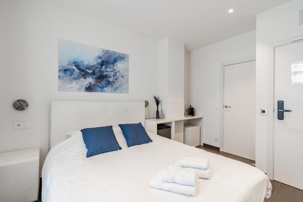 ein Schlafzimmer mit einem weißen Bett und Handtüchern darauf in der Unterkunft Maison Bruges in Brügge