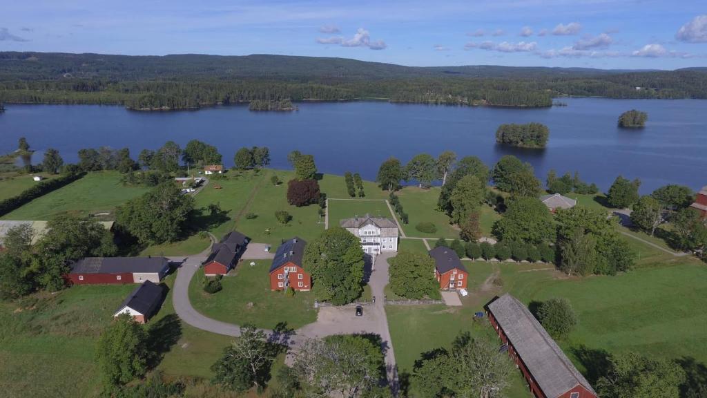 an aerial view of a house next to a lake at Svaneholm Hotel in Svanskog
