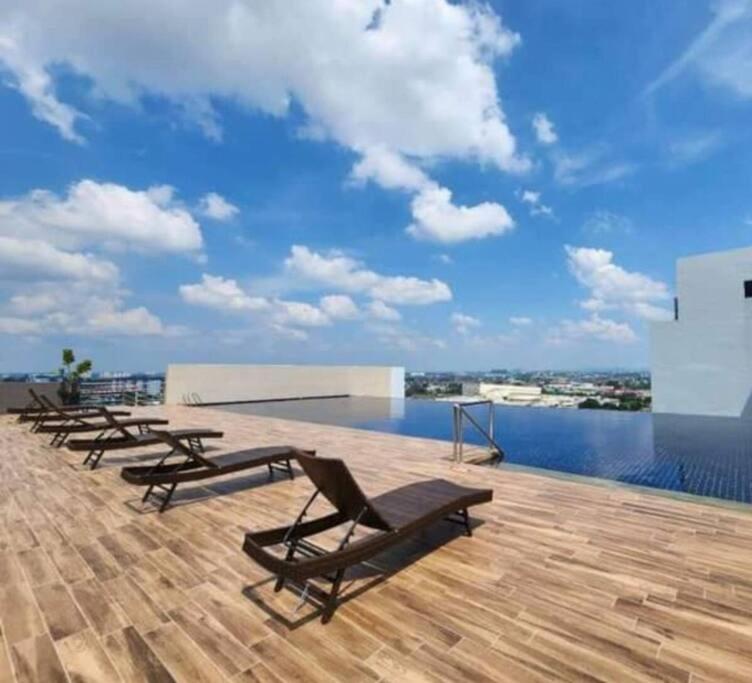 a row of chaise lounges on the roof of a building at The Podium Studio@Amy*Home in Kuching